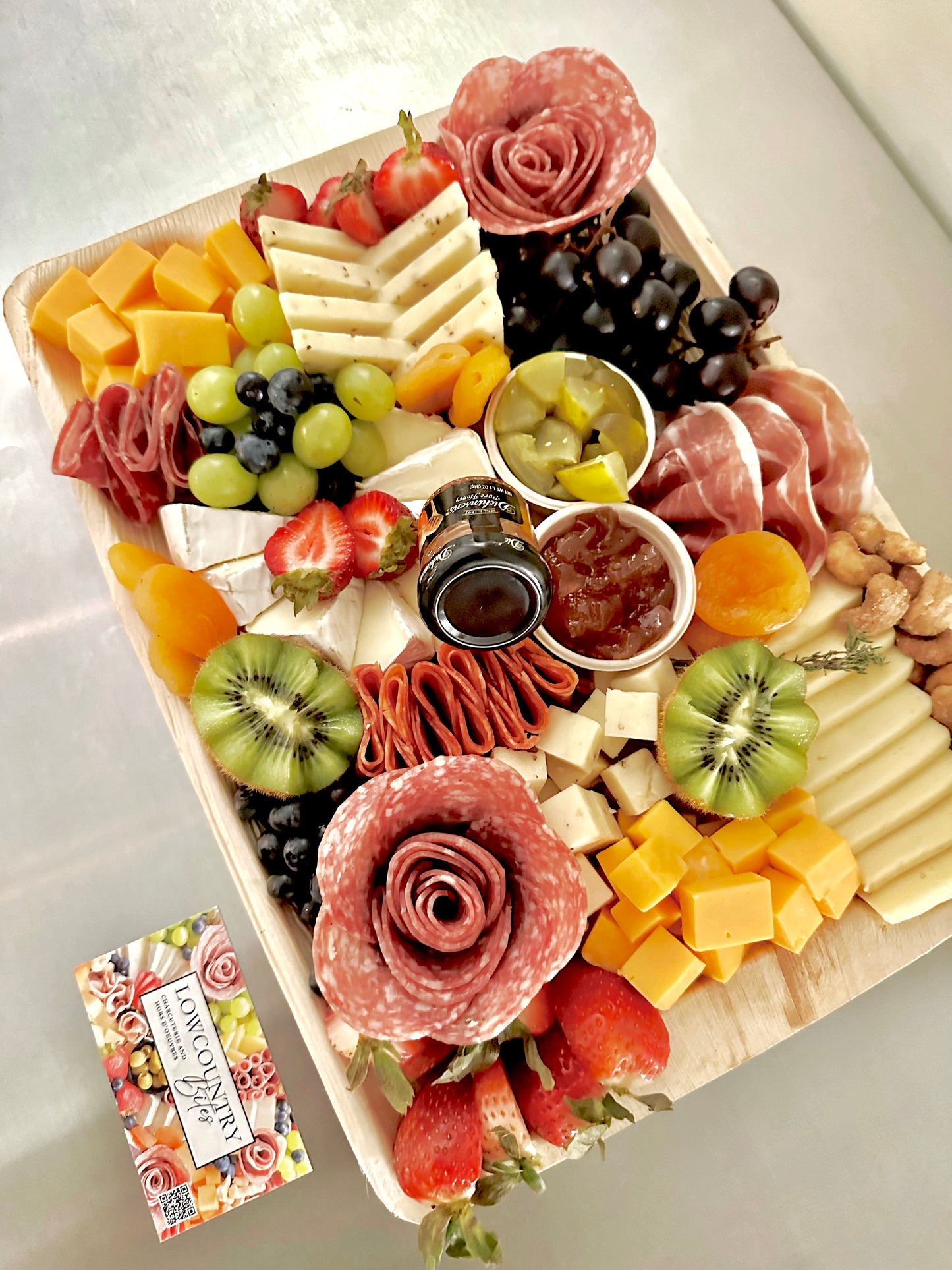 A charcuterie board featuring an assortment of cheeses, meats, fruits, and nuts, arranged elegantly on a wooden platter.