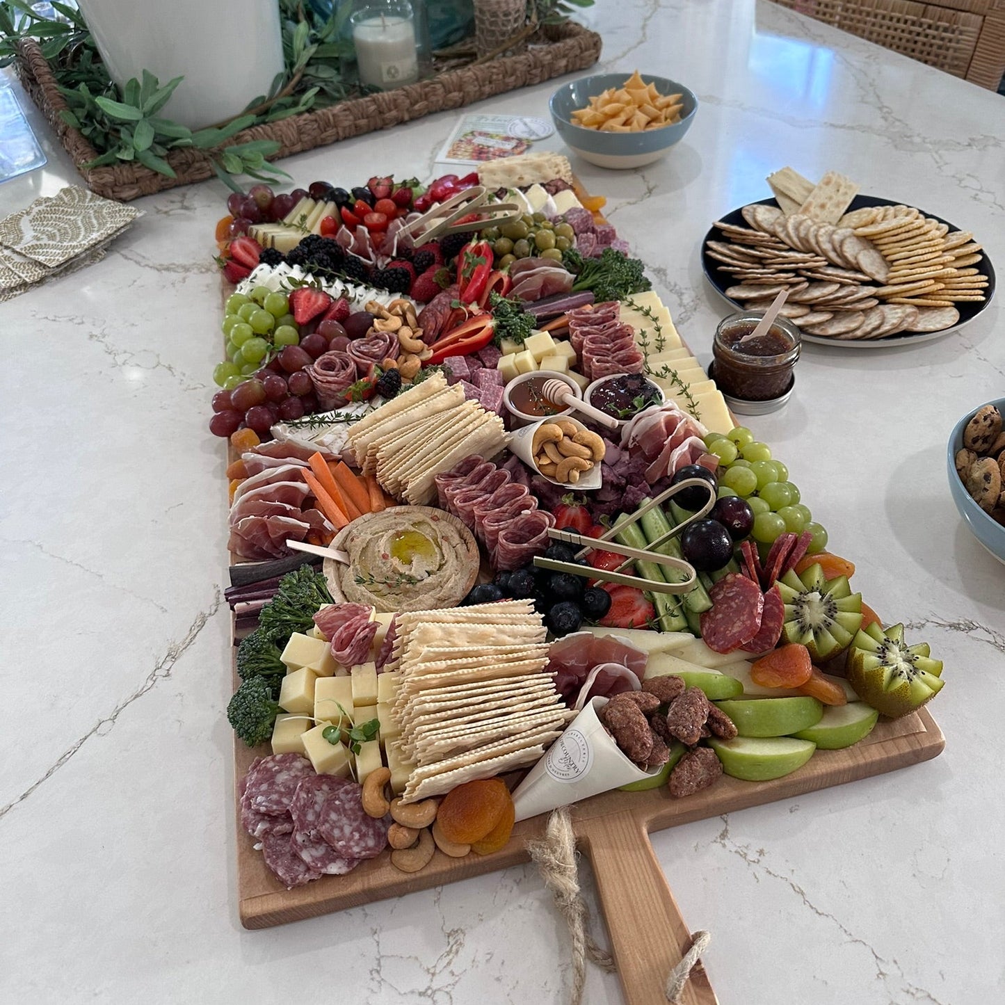 Assorted charcuterie board with meats, cheeses, and fruits on a marble table.
