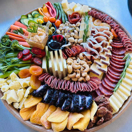 Assorted charcuterie board with meats, cheeses, and vegetables on a platter.