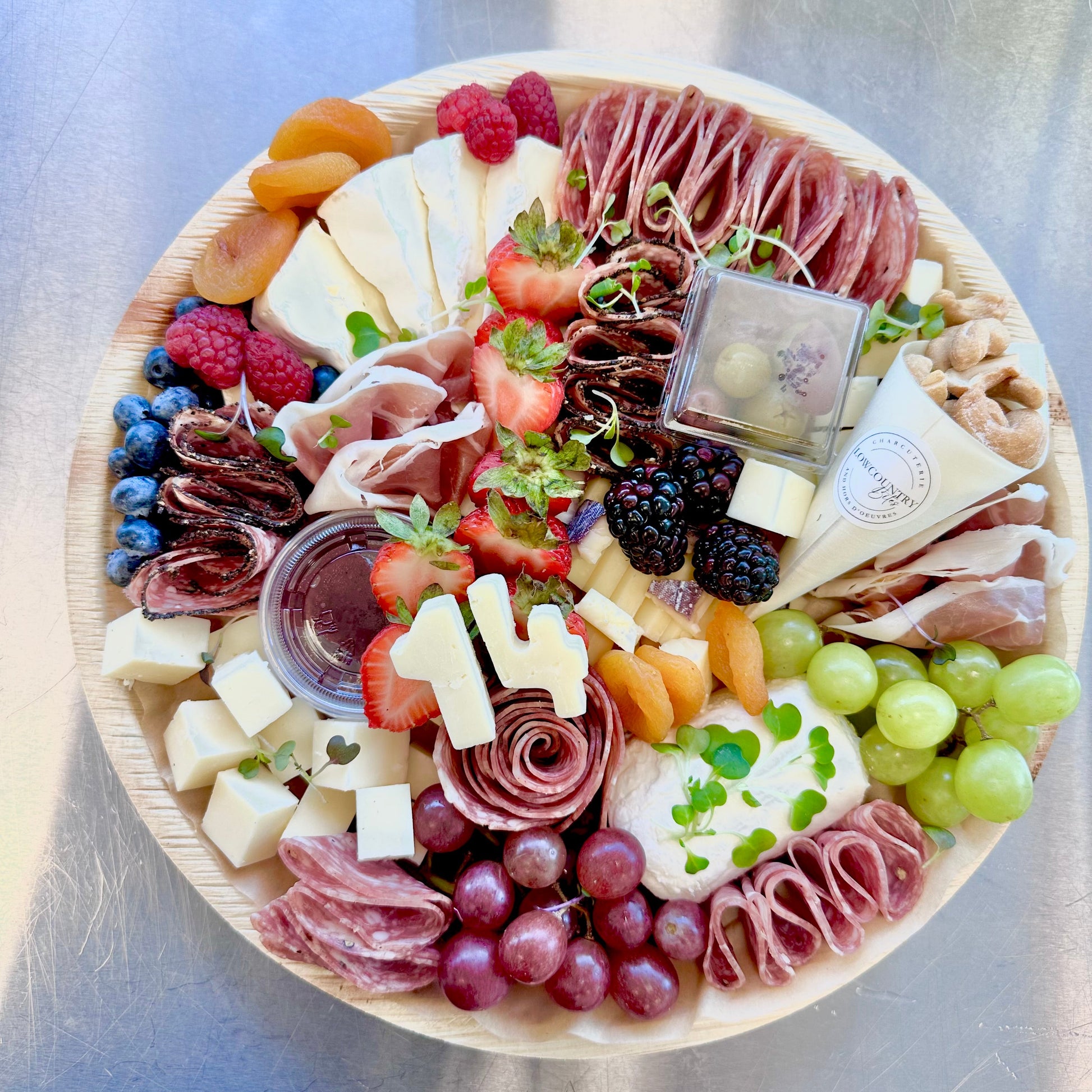 A charcuterie board featuring an assortment of cheeses, meats, fruits, and nuts, arranged elegantly on a platter.