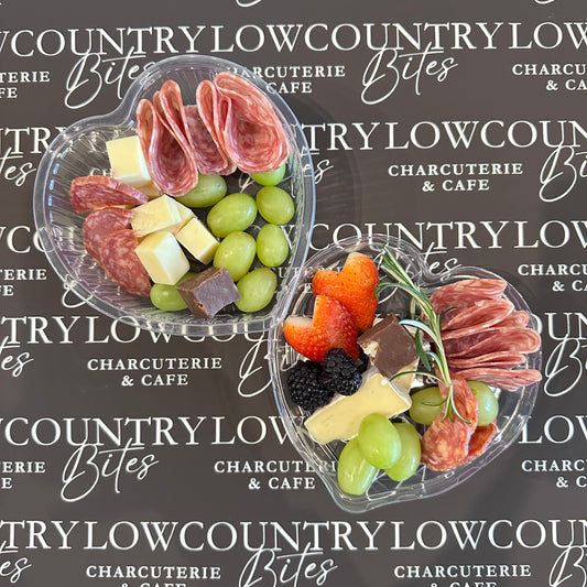 Platters of assorted meats, cheeses, and fruits on a branded background